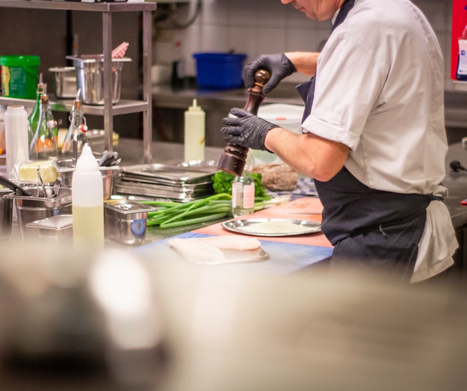Instructor demonstrating whole food preparation techniques in kitchen classroom